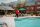 The Governor mascot waving next to a pool